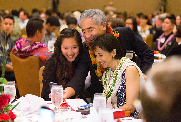 Allen Uyeda, former CEO of First Insurance Company of Hawaii (FICOH), smiling with a student at our annual Business Night event.
