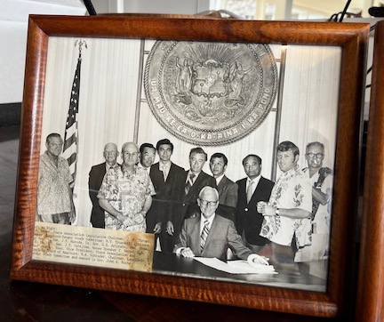 A photo of Red (second from right) with Gov. John A. Burns in his office.