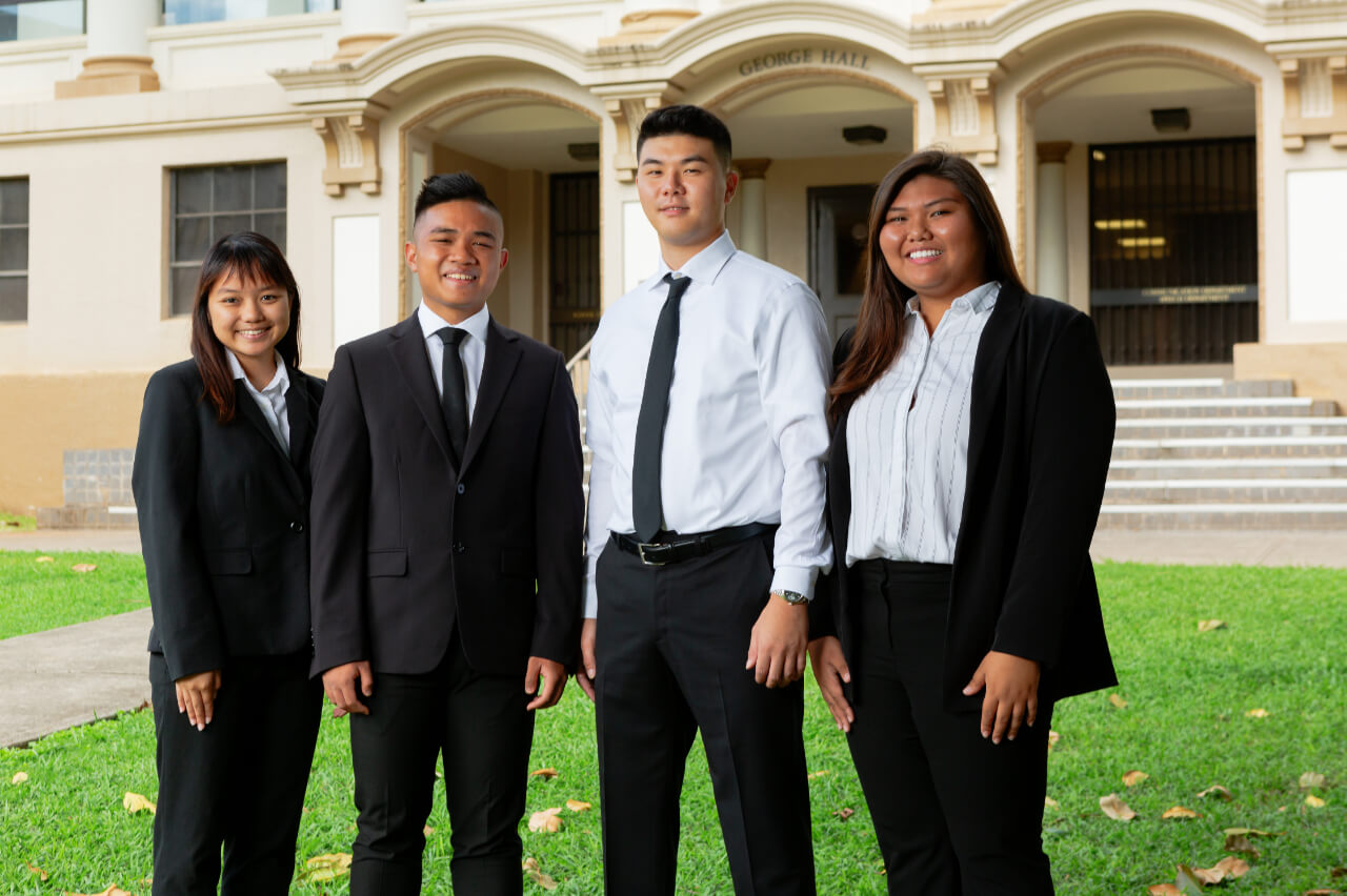 Students posing for a picture in front of George Hall.